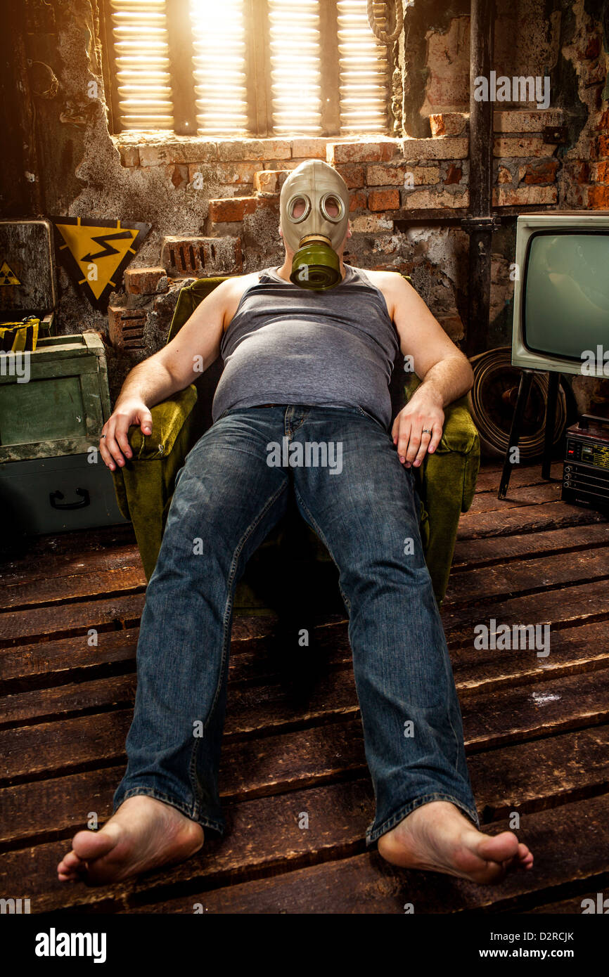 Persona en una máscara de gas se sienta en un sillón Foto de stock