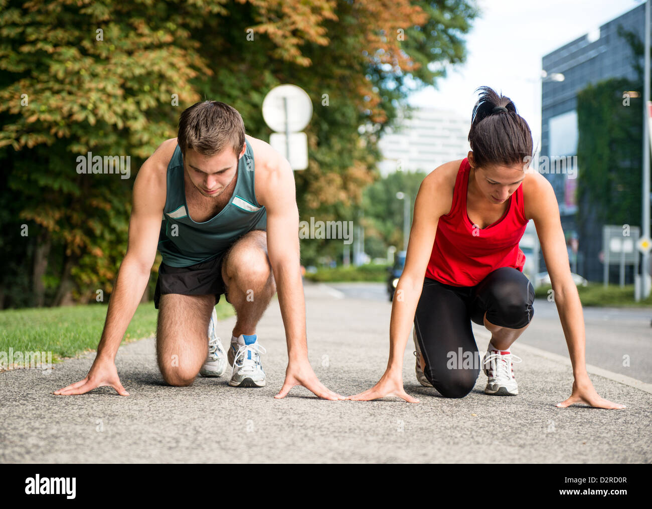 Deporte joven pareja en posición inicial preparado para competir y ejecutar Foto de stock