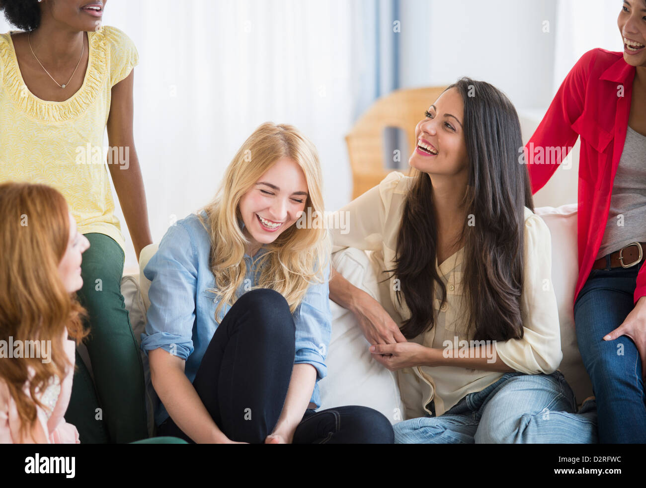 Mujer sonriente hablando en el sofá Foto de stock