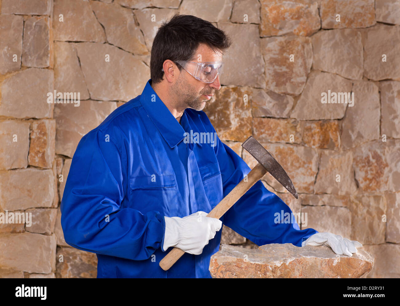 La masonería mason picapedrero hombre con martillo trabajando en la  construcción de pared de piedra Fotografía de stock - Alamy