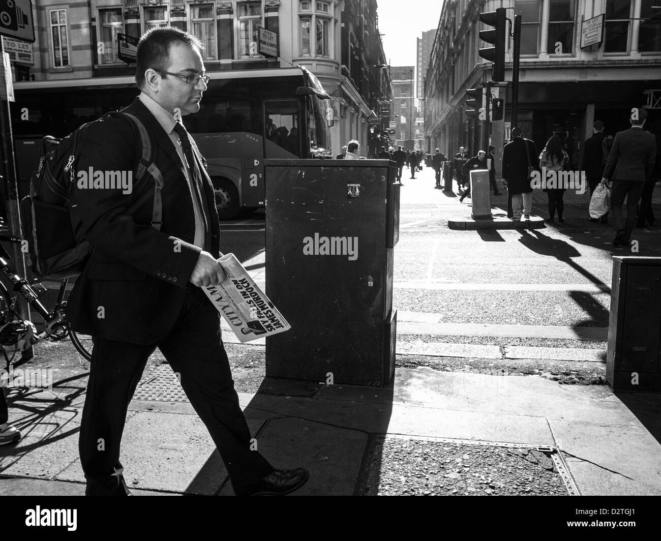 Empresario con papeles de una calle peatonal en la luz de la mañana Foto de stock