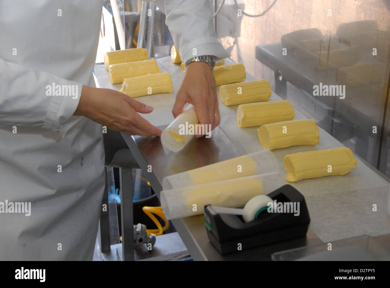 Rollos de embalaje de materias mantequilla orgánica en una granja lechera en East Sussex, Inglaterra Foto de stock