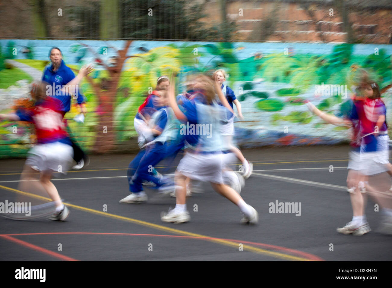 Los niños de escuela primaria jugando baloncesto match en el patio escolar Foto de stock