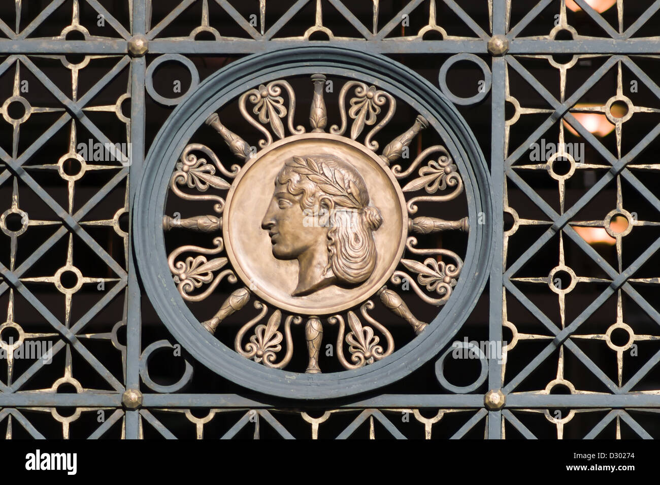 Ornamento en el antiguo portón forjado. Una cabeza de mujer Foto de stock