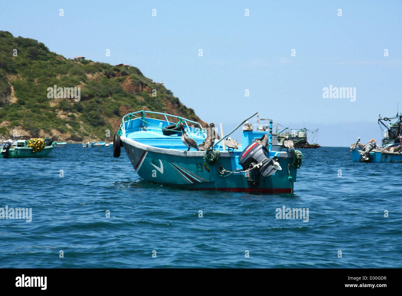 Pequeños barcos de pescadores en el agua azul. Ecuador. Foto de stock