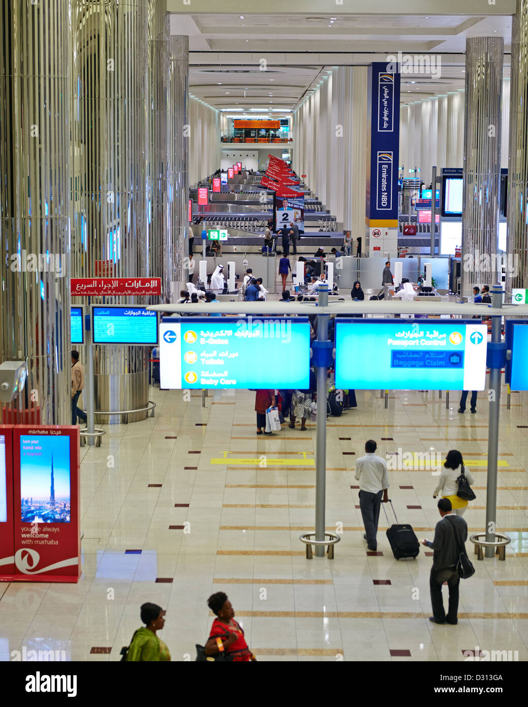 El ajetreo y el bullicio de pasajeros en la terminal de llegada y salida del aeropuerto internacional de Dubai Foto de stock