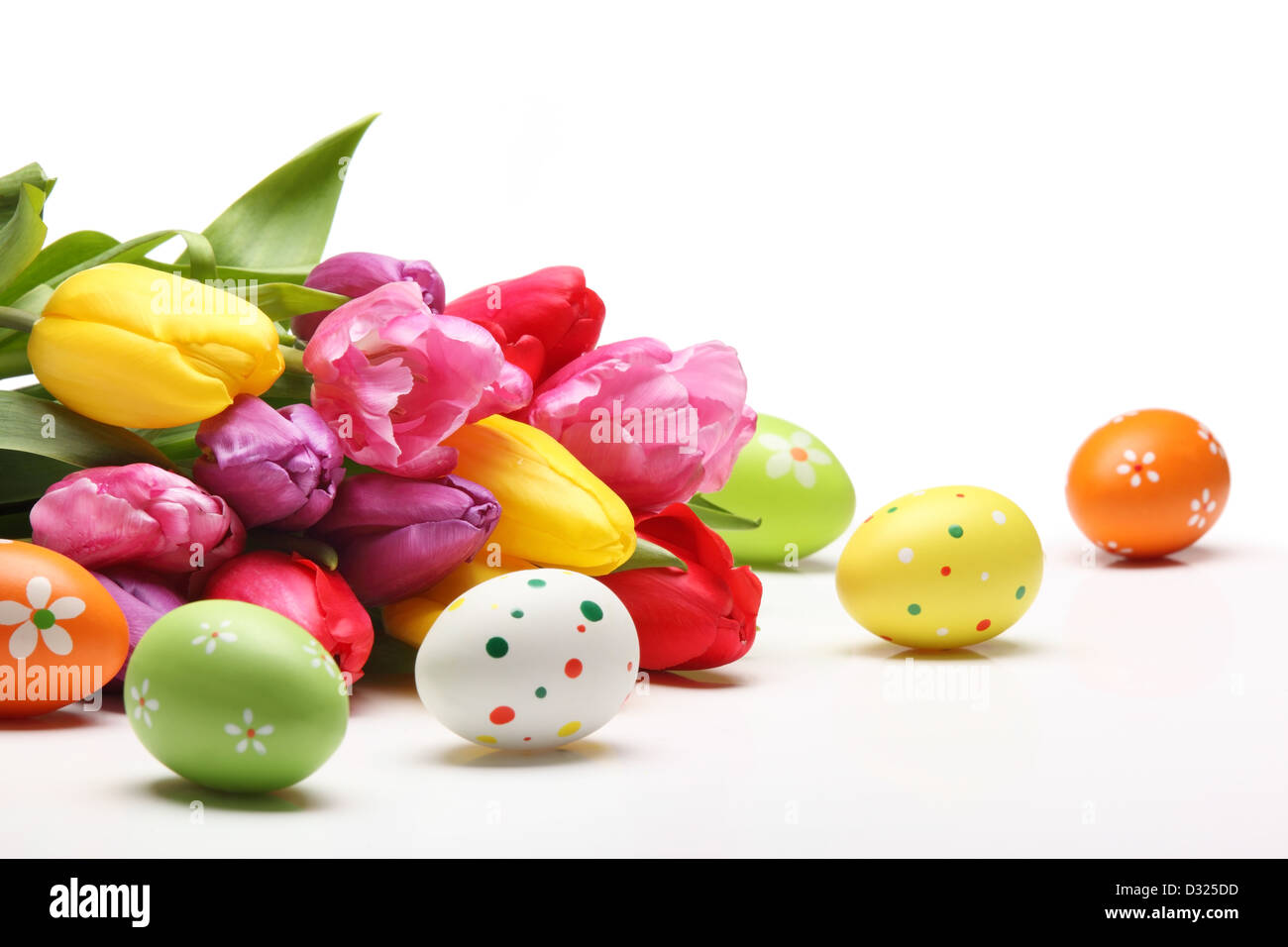 Los huevos de Pascua con tulipanes en fondo blanco. Foto de stock