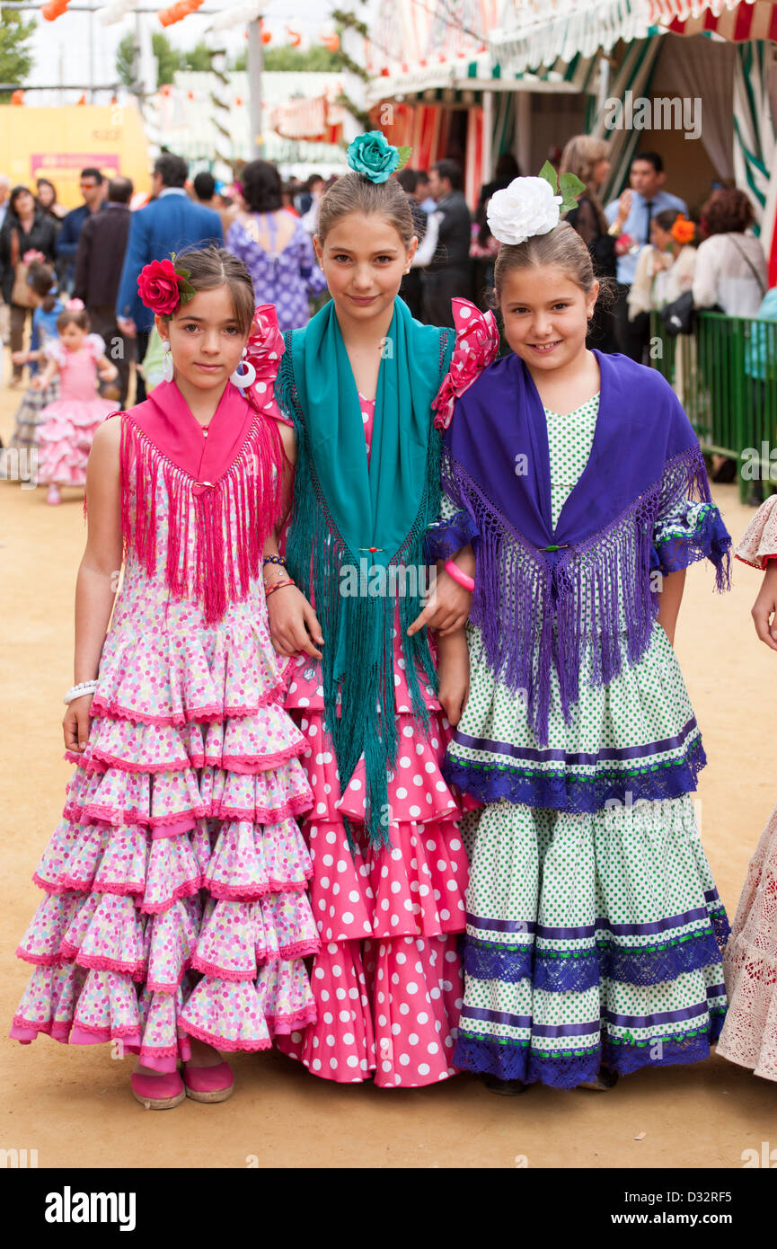 Jóvenes muchachas vestidas con coloridos trajes de flamenca durante la Feria de Sevilla, España. Foto de stock