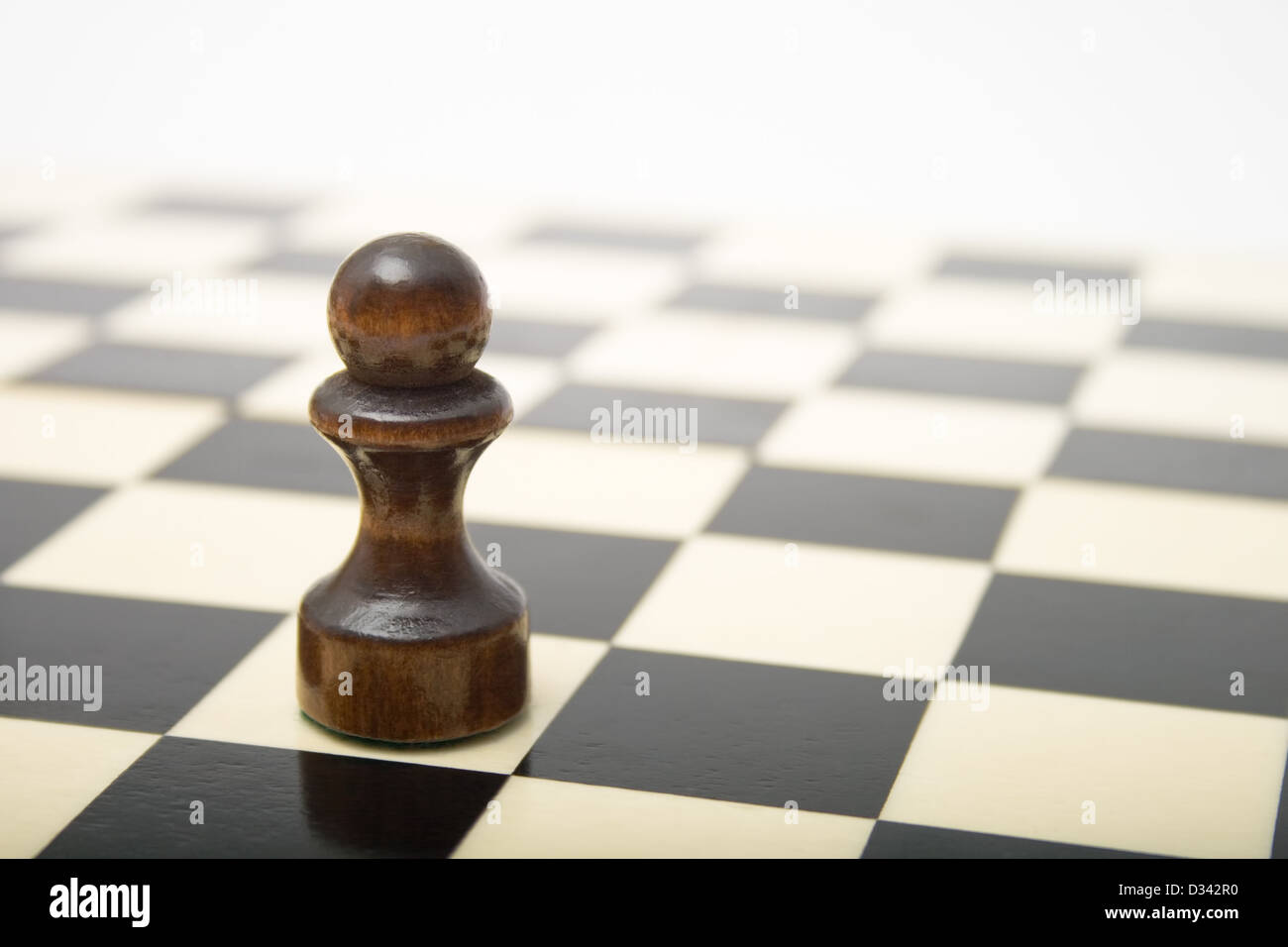 Peón negro sobre un tablero de ajedrez Foto de stock
