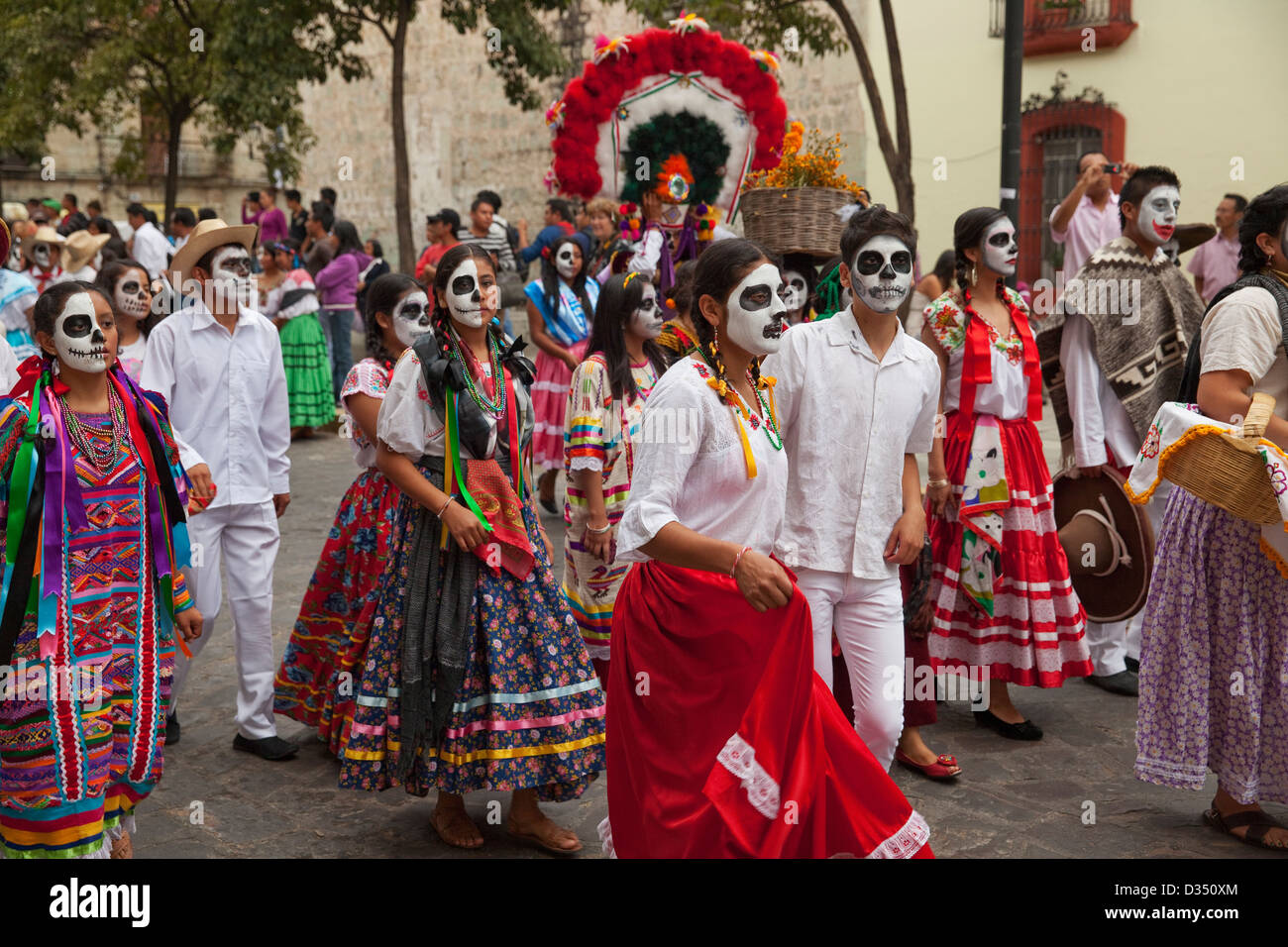 Desfile del Día de los muertos con participantes en trajes tradicionales y espectadores en