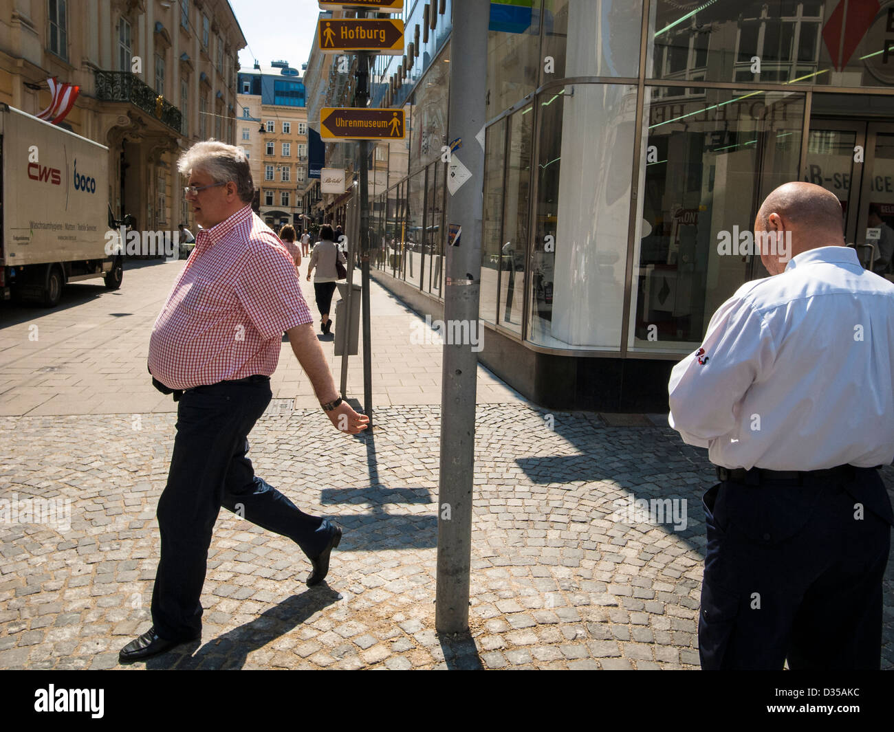 Un hombre en edad midlle caminando calle soleada Foto de stock
