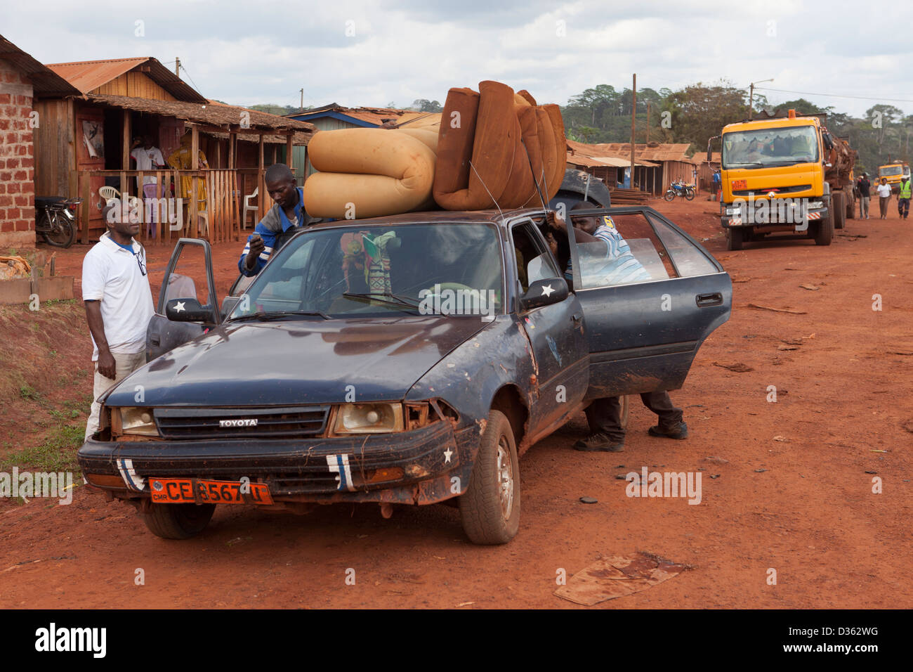 Camerún, 2 de octubre de 2012: Un taxi carga con pasajeros y mercancías en un pequeño pueblo en el bosque. Foto de stock