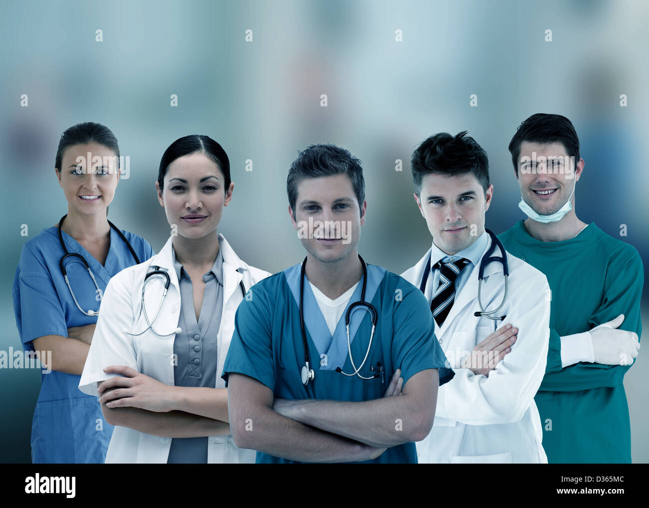 Trabajadores del hospital sonriente de pie con los brazos cruzados en línea Foto de stock