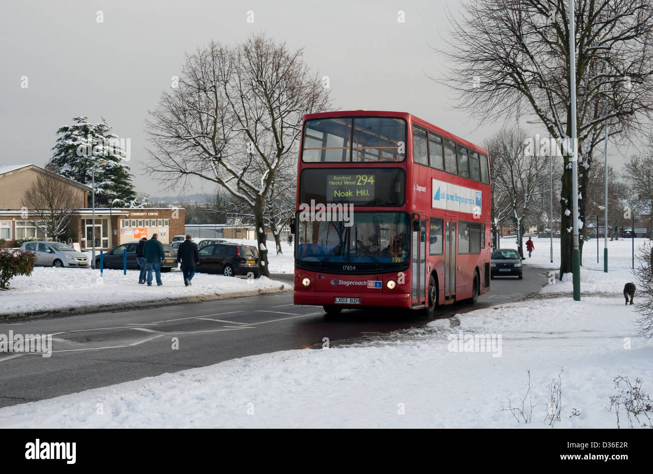 Un Dennis Trident operado por Stagecoach London hace su camino a Noak Hill pasado aceras cubiertas de nieve Foto de stock
