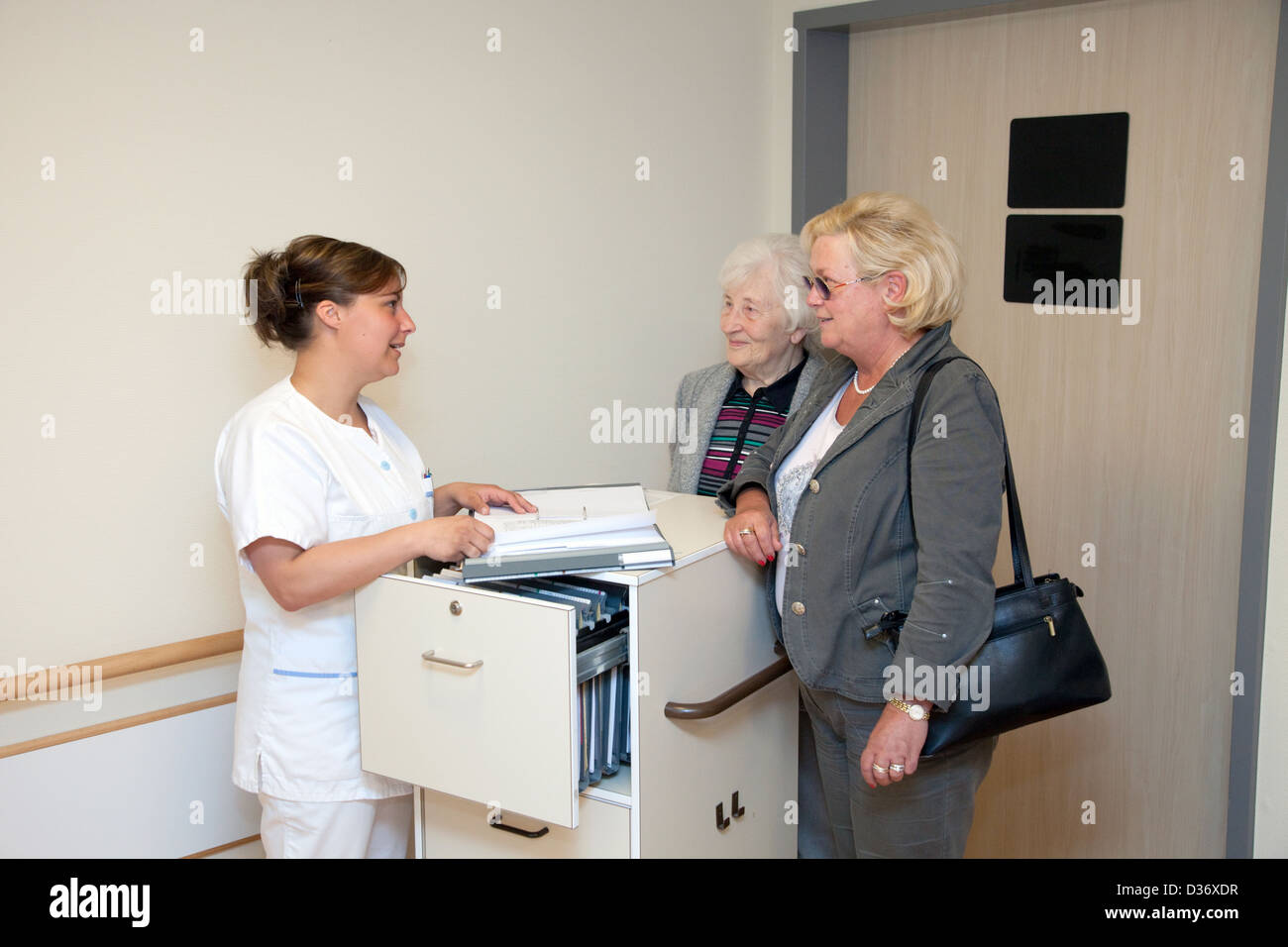 Essen, Alemania, una enfermera geriatrica unterhaelt con familiares Foto de stock