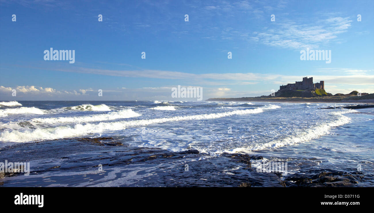 Foto panoramica de surf en playa, Bamburgh Castle, Northumberland, noreste de Inglaterra, Reino Unido, GB Foto de stock