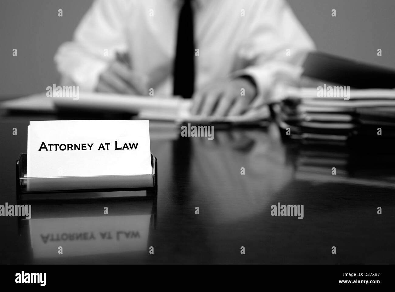 Attorney At Law sentados frente al escritorio sosteniendo pen con archivos con business card Foto de stock