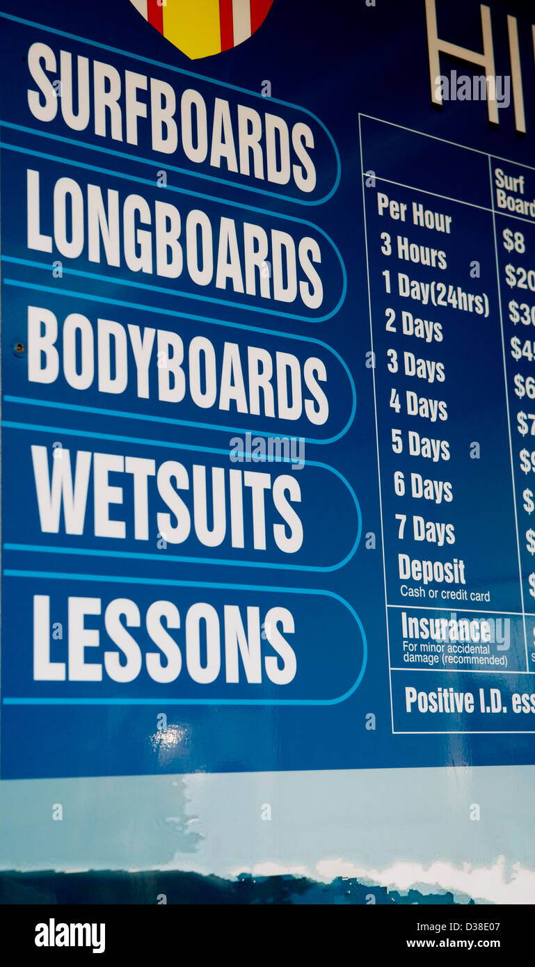 Tabla de surf longboard bodyboard trajes lecciones letrero azul publicidad alquiler de deportes acuáticos Foto de stock