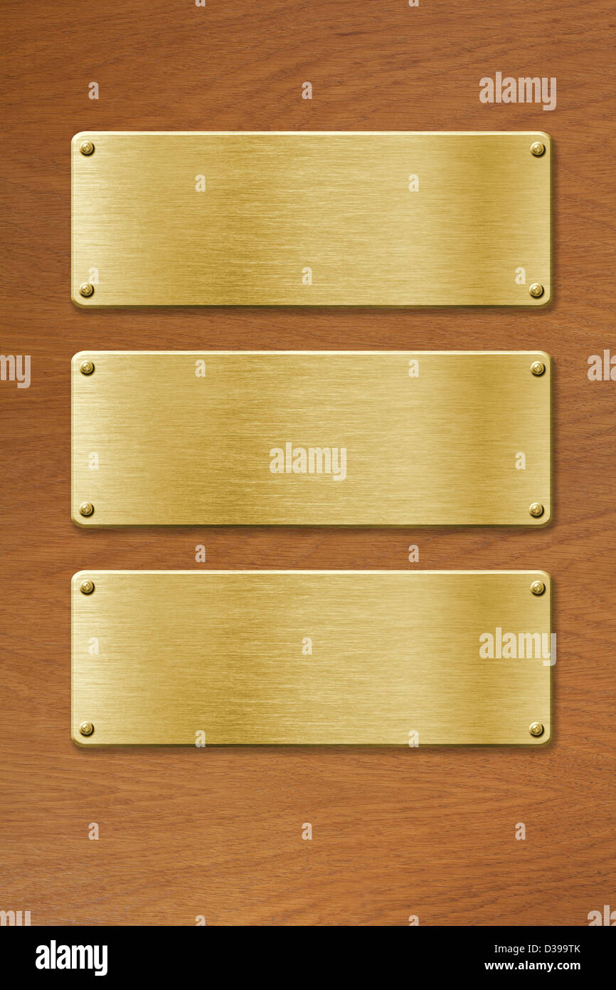 Tres placas de metal dorado sobre la textura de la madera Foto de stock