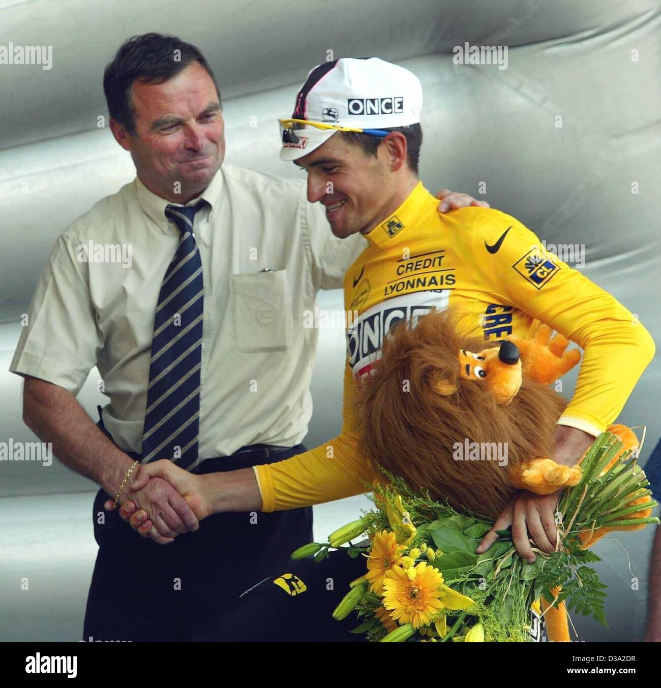 (Dpa) - El cinco veces campeón del Tour de Francia Bernard Hinault (L) se da la mano con el ciclista español Igor González de Galdeano del equipo Once-Ersoki quien viste el maillot amarillo durante la 9ª etapa del Tour de Francia en Pont-Scorff, 15 de julio de 2002. Foto de stock