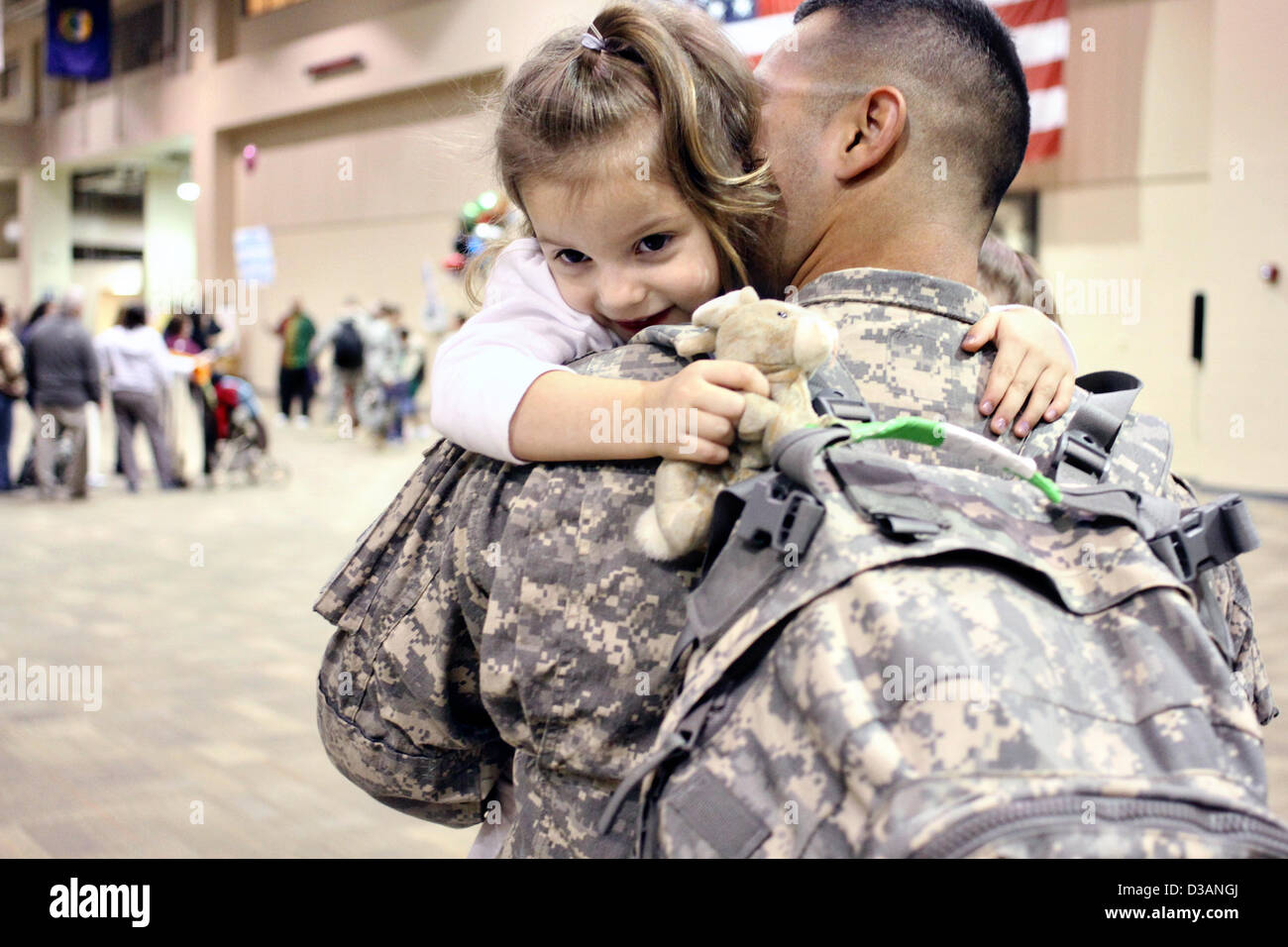 US Army Spc. José Cisneros abraza a su hija Rosalyn tras regresar de un despliegue de nueve meses a Kuwait el 14 de febrero de 2013 en Fort Benning, GA. Más de 300 soldados fueron reunidos con sus familiares y amigos justo a tiempo para celebrar el Día de San Valentín. Foto de stock