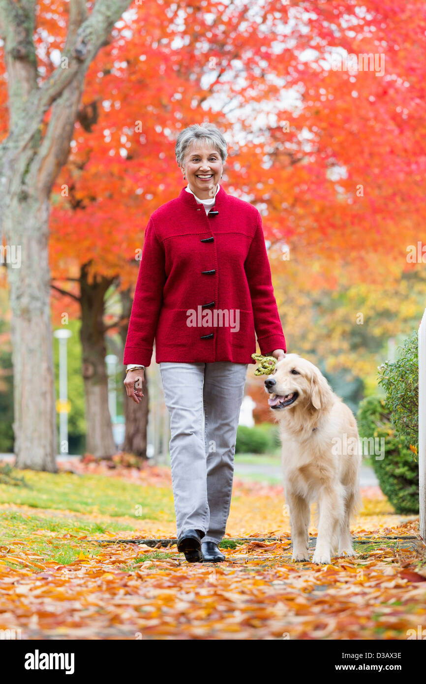 Mujer paseando a un perro de raza mixta Foto de stock