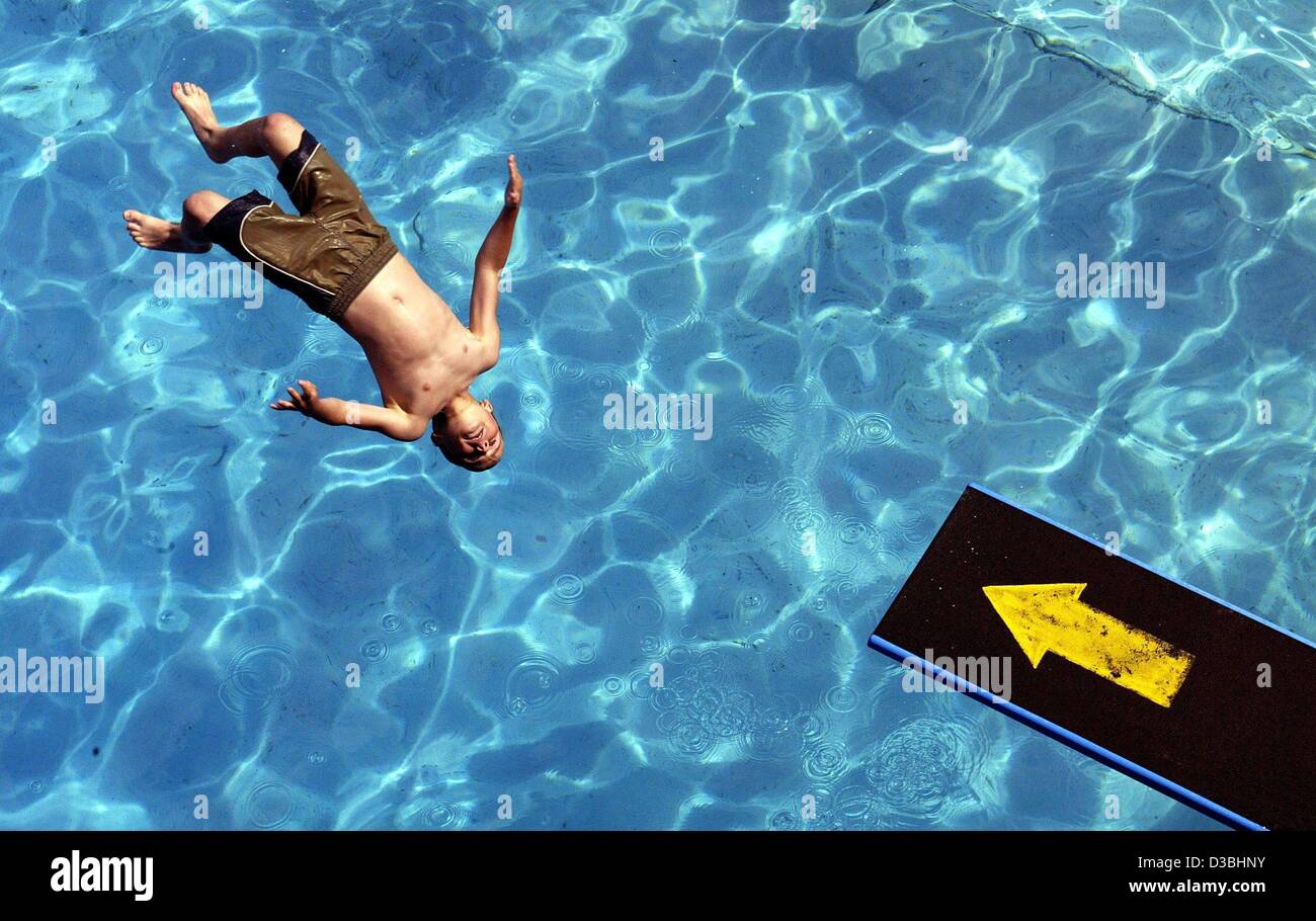 (Dpa) - Un niño se salta de un trampolín a la refrescante agua a lido en Kaiserslautern, Alemania, el 2 de junio de 2003. Cálido, brillante y soleado clima es la previsión para Alemania. Foto de stock