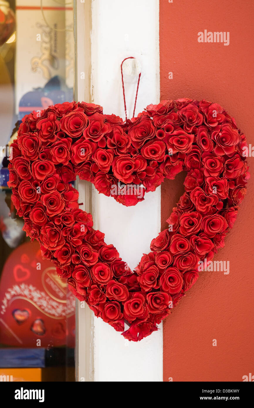 Corazón de rosas artificiales en una pared. Foto de stock