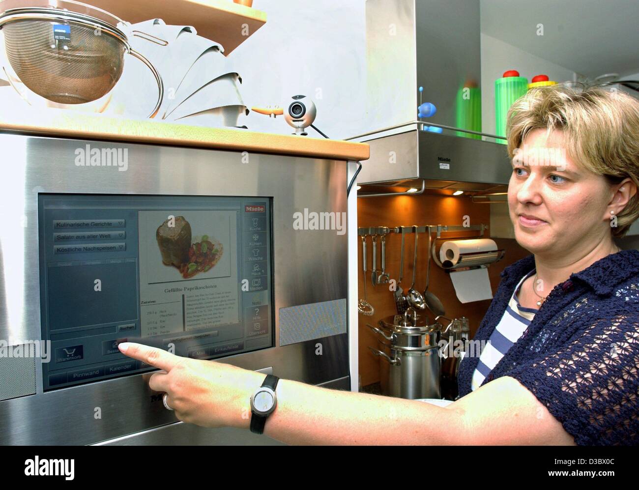 (Dpa) - Sabine Hildebrand pulsa un botón en la pantalla táctil de una despensa de cocina en una casa de prueba del Instituto Fraunhofer de circuitos microelectrónicos y sistemas (IMS) en Duisburgo, Alemania, 28 de junio de 2003. El Instituto junto con los fabricantes de los equipos domésticos desarrollar el comp Foto de stock