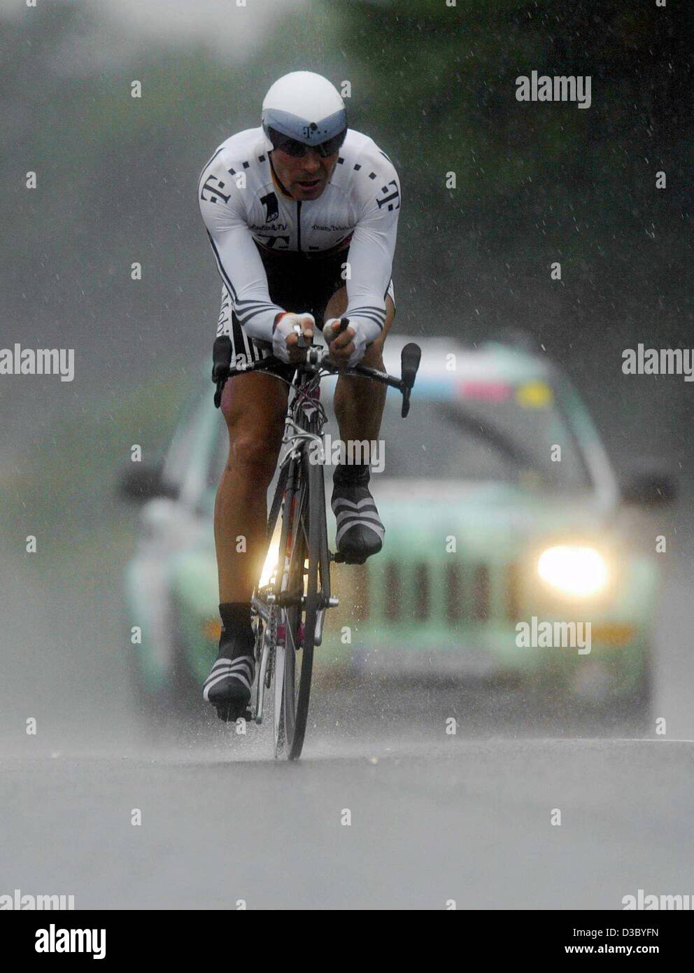 (Dpa) - El alemán Erik Zabel, del equipo Telekom es seguido por el equipo del coche ya que se alimenta a través de una lluvia torrencial durante la contrarreloj individual de la 19ª etapa del Tour de Francia 2003 carrera de ciclismo desde Pornic a Nantes, Francia, el 26 de julio de 2003. Foto de stock