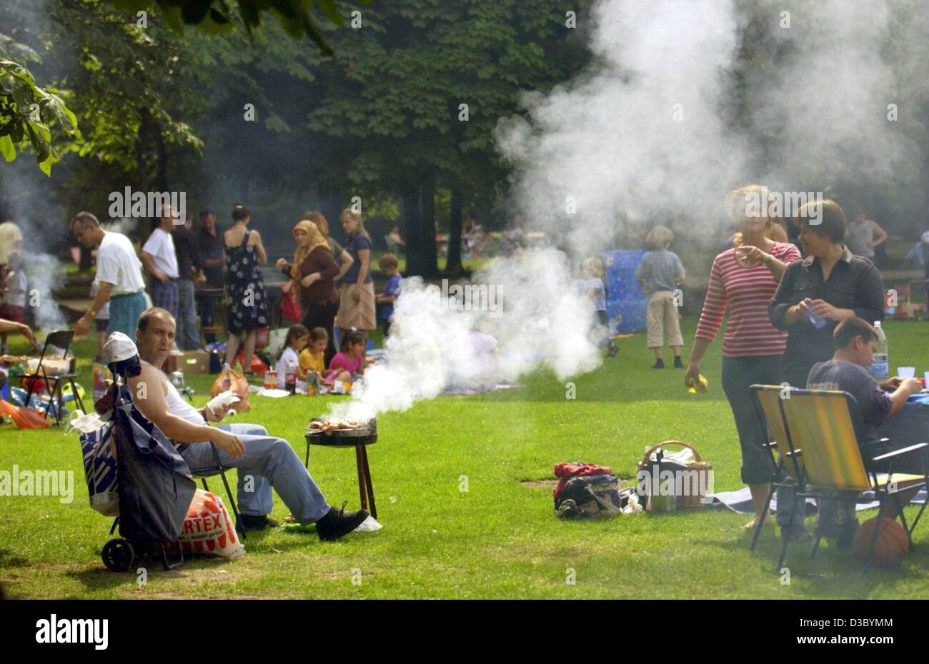 (Dpa) - Un hombre se sienta delante de su parrilla de fumadores entre muchas personas de ideas afines en el parque Tiergarten en el centro de Berlín, el 28 de junio de 2003. Cada fin de semana, alrededor de 40.000 visitantes pasan su tiempo libre en el parque Tiergarten. Foto de stock