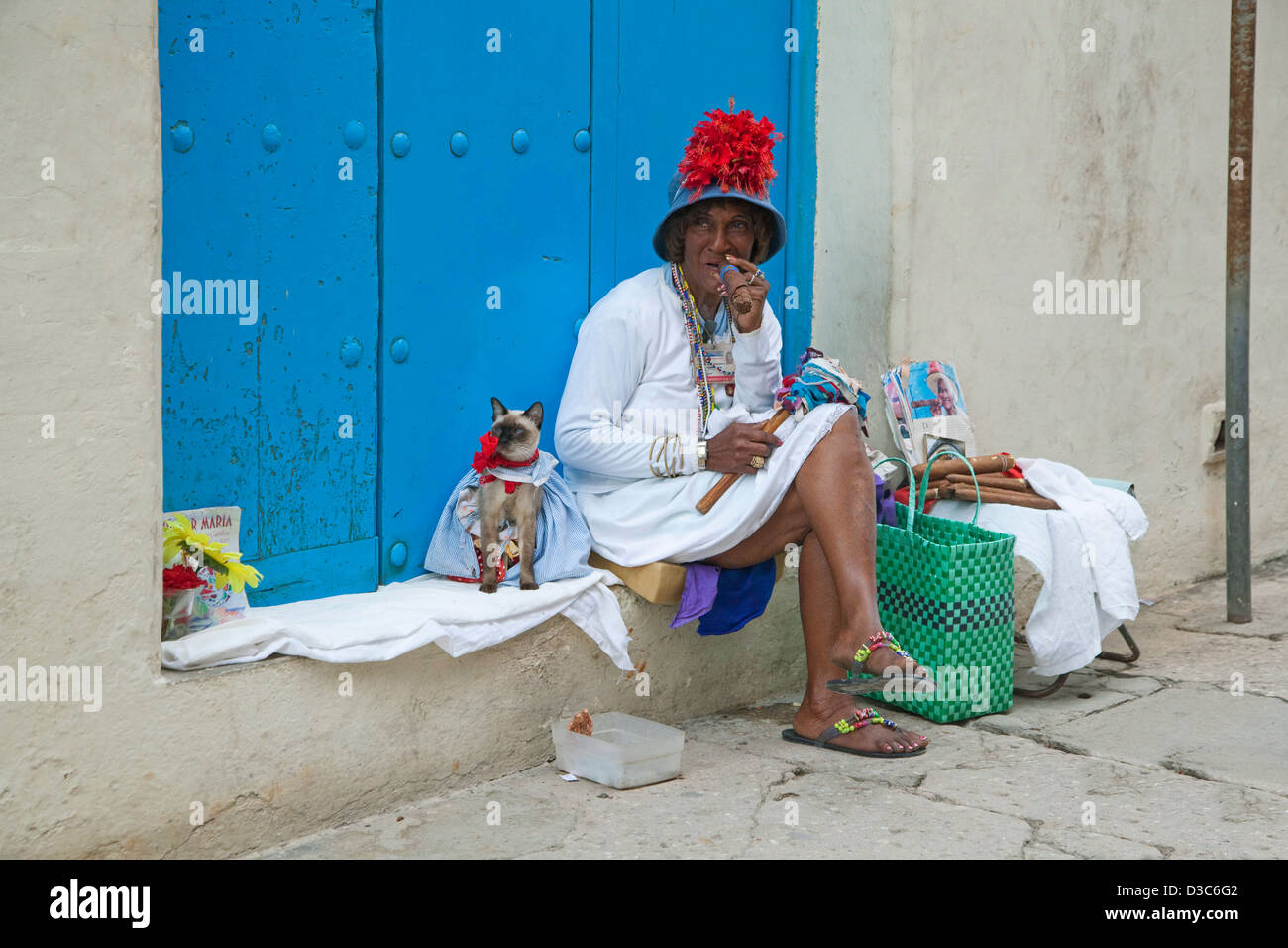 Modelo de calle con licencia posando para turistas como coloridas mujer cubana tabaco habano enorme y vestida de gato en la Habana Vieja, Cuba Foto de stock