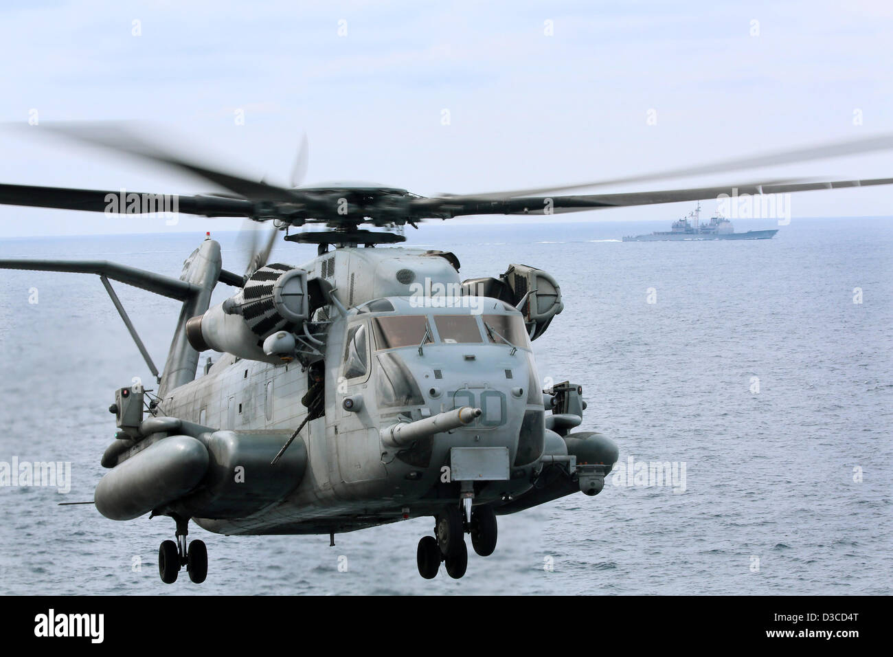 Marine estadounidense del tipo CH-53E Super Stallion realiza operaciones de vuelo de helicóptero cerca del crucero de misiles guiados USS Anzio y el buque de asalto anfibio USS Kearsarge, 14 de febrero de 2013 en el Océano Atlántico. Los buques que participan en un programa conjunto de capacitación con los marineros del Reino Unido. Foto de stock