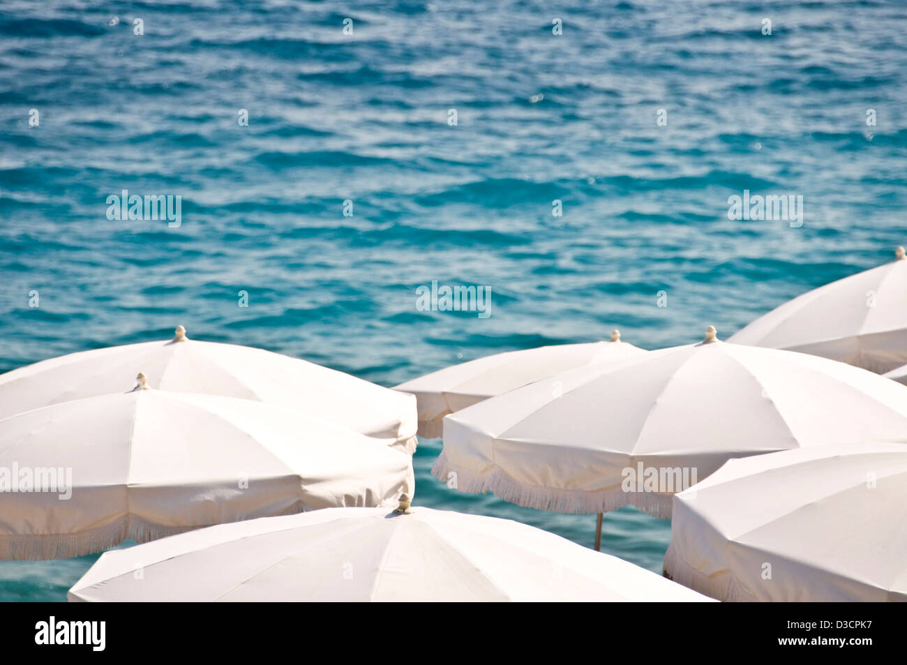 Playa privada con sombrillas de playa blanca, en el fondo del mar vista desde arriba - Niza, Francia Foto de stock