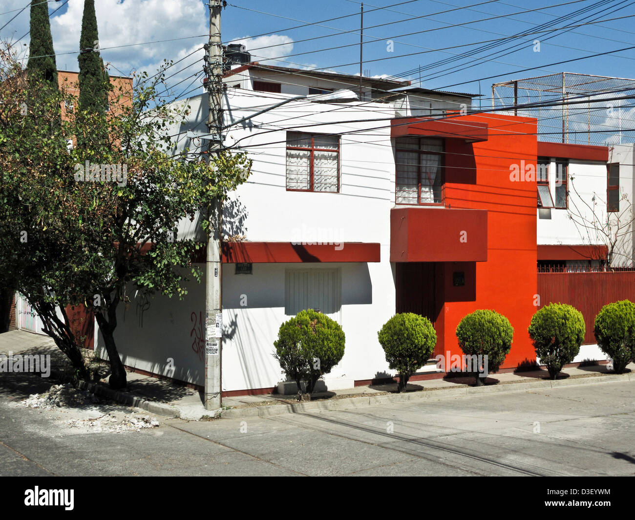 Impresionante exterior de yeso pintado de blanco cúbico de casa moderna con paredes en tonos rojos en zona residencial Oaxaca de Juárez en México Foto de stock