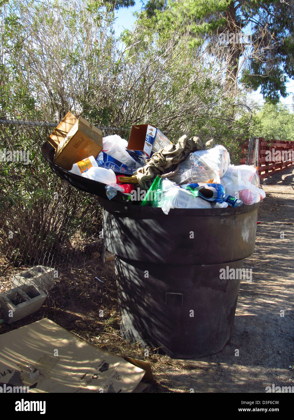 Contenedor de basura residencial rebosante de basura Foto de stock
