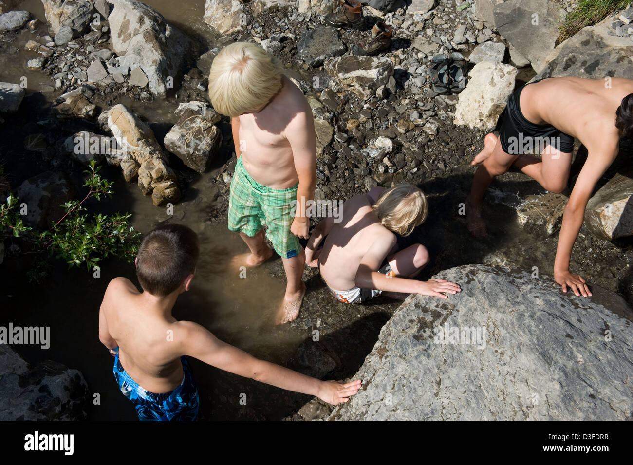 Alm Blatti, Suiza, muchachos lavarse en un río Foto de stock