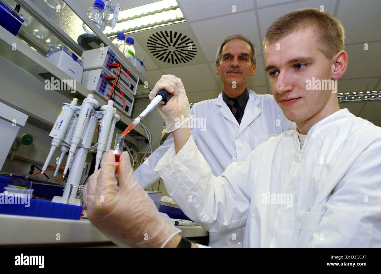 Dpa) - La biotecnología farmacéutica estudiante Karsten Doenitzsch tintes  una solución en un tubo de ensayo bajo la supervisión del Profesor Dr.  Kuenkel en el nuevo laboratorio de ingeniería genética en la