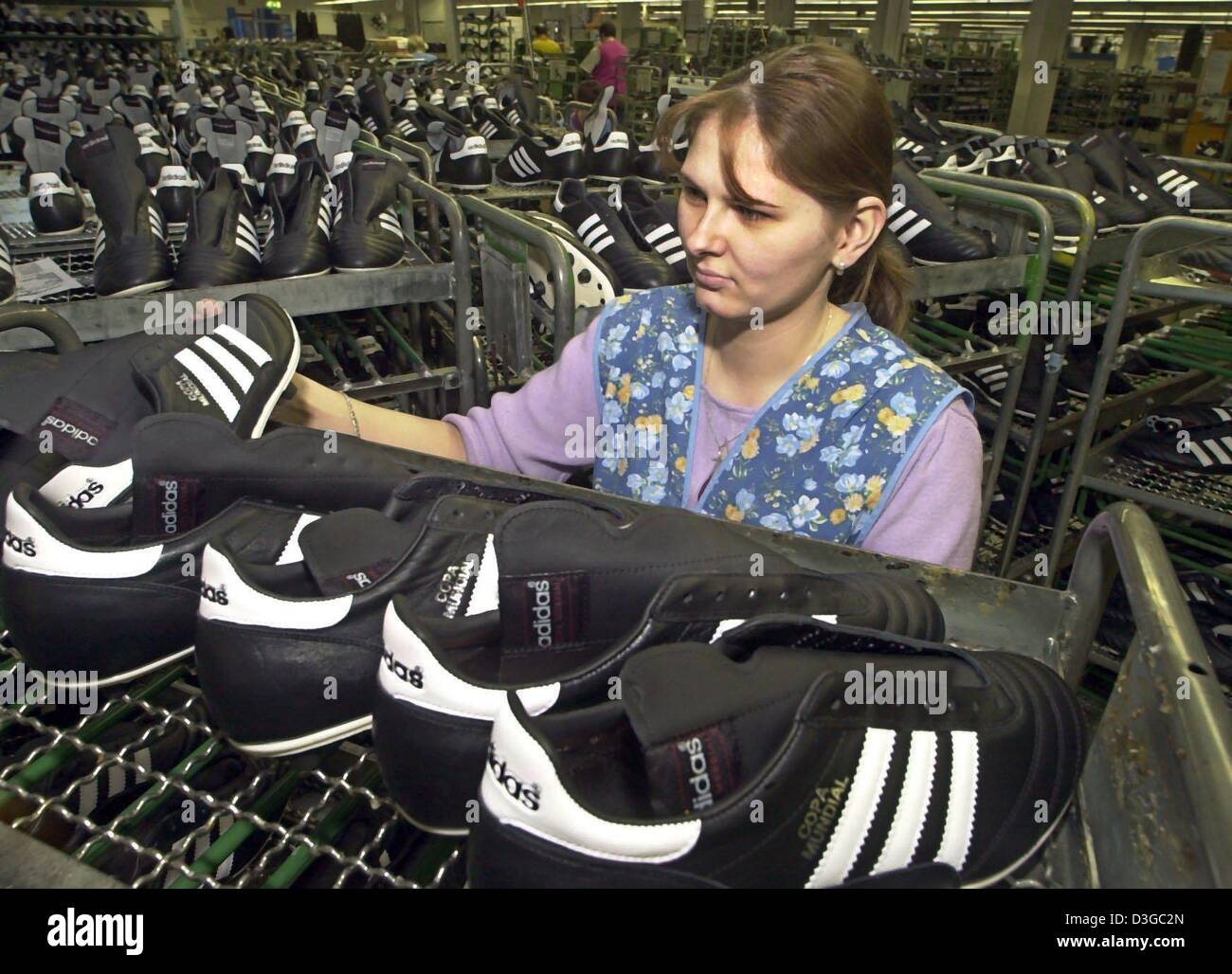 Los archivos de datos (DPA) - Ramona Rehmer empleado inspecciona nuevos  zapatos en una planta de producción del fabricante de ropa deportiva adidas  en Scheinfeld, Alemania, 6 de marzo de 2004. Las