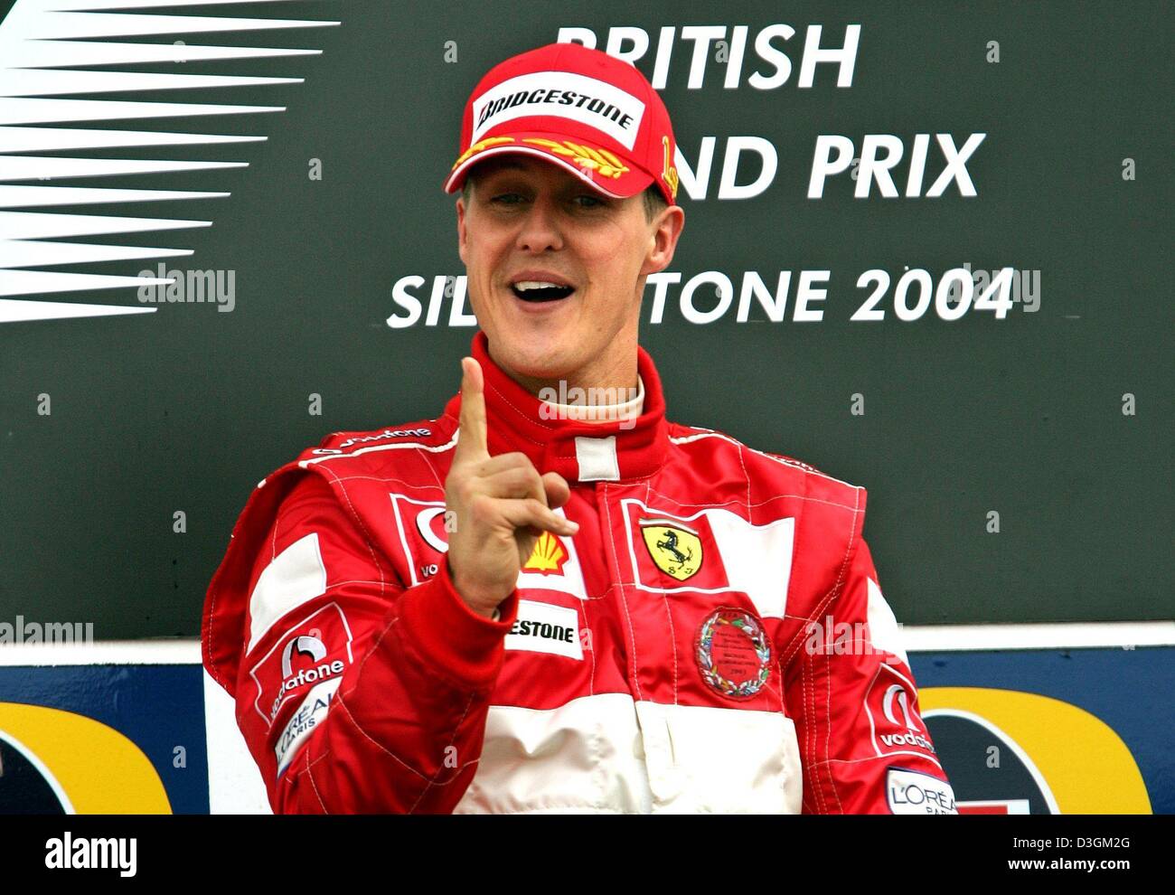Dpa) - El alemán Michael Schumacher, piloto de Fórmula uno de Ferrari  jubilates en el podio tras ganar el Gran Premio de Gran Bretaña en  Silverstone, Inglaterra, 11 de julio de 2004.
