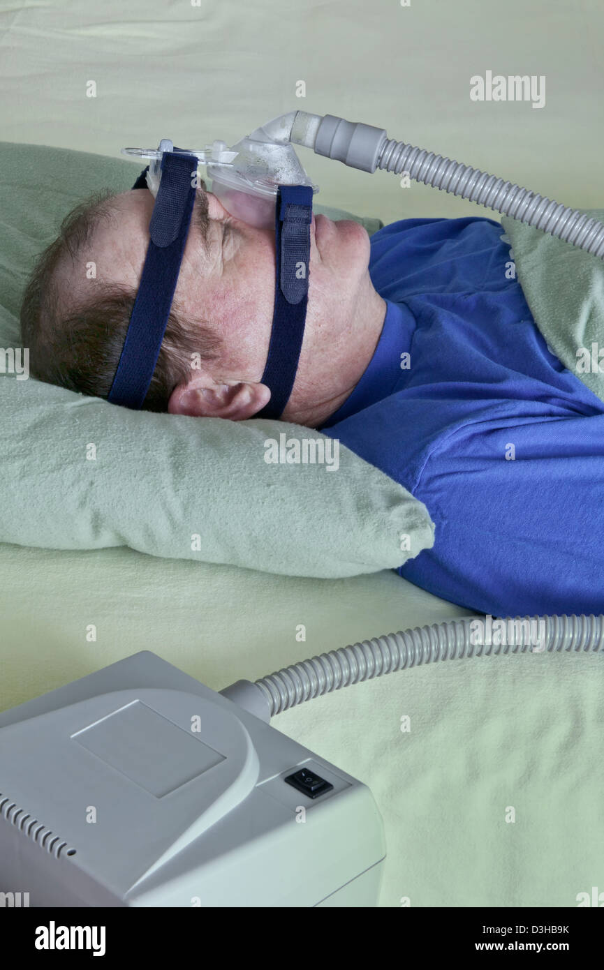 Senior masculino utilizando el dispositivo de CPAP. Foto de stock