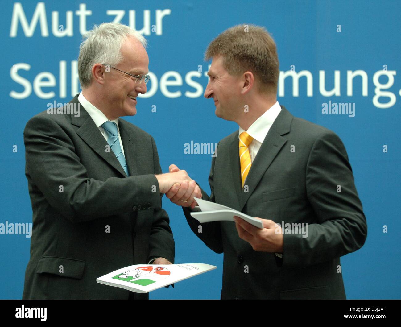 (Dpa) - El presidente del Partido Conservador -CDU en Renania del Norte-Westfalia y el Primer Ministro designado, Juergen Ruettgers (L), y el presidente del partido liberal FDP, Andreas Pinkwart, estrecharse las manos tras el cambio de la firma del tratado de coalición en Duesseldorf, Alemania, el lunes 20 de junio de 2005. Después, el lunes 20 de junio de 2005, dirigentes de los partidos de la coalición habían firmado trea Foto de stock