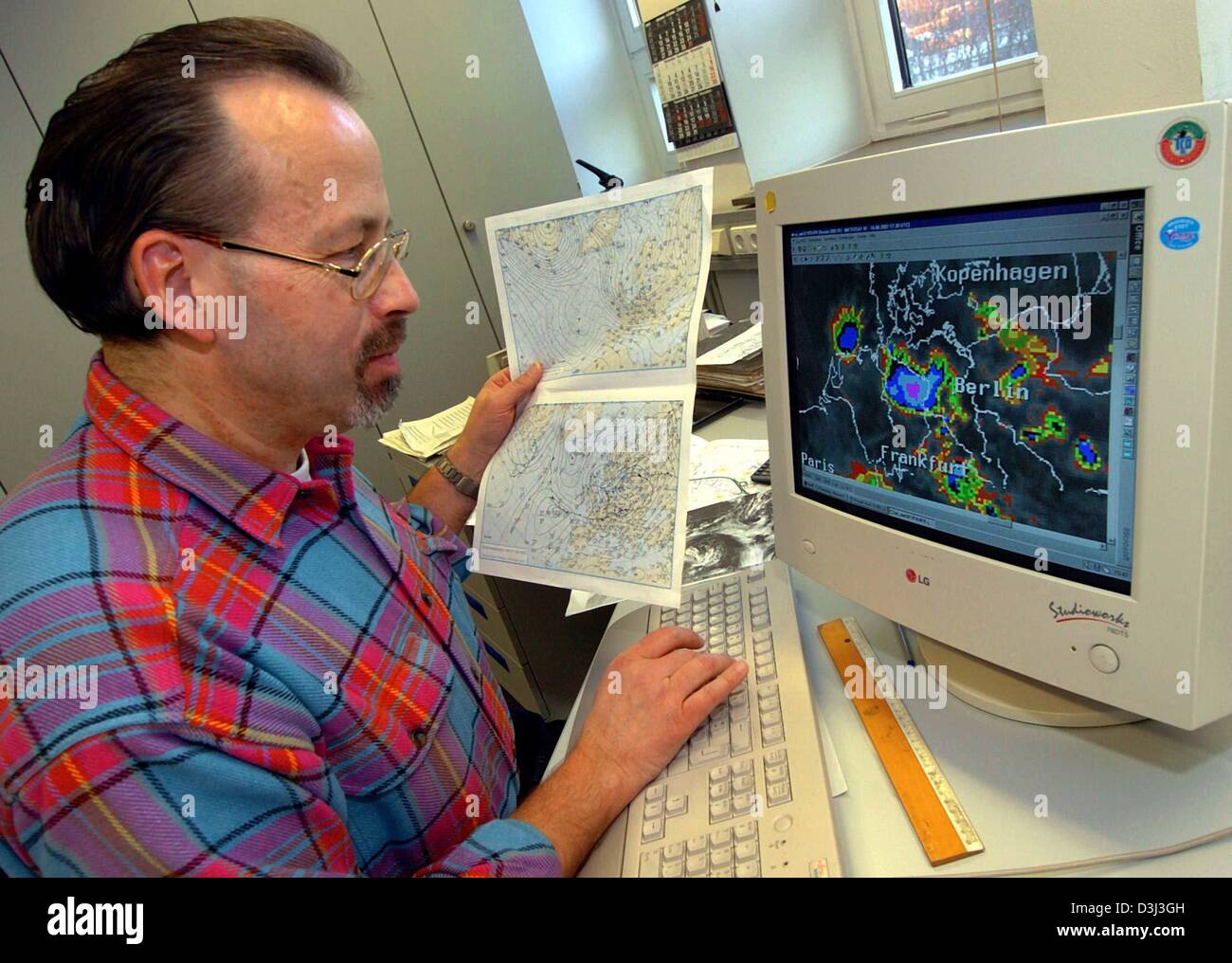 (Dpa) - El meteorólogo Uwe Wienert mira frentes de tormenta en su pantalla de ordenador en las oficinas del servicio meteorológico alemán en Hannover, Alemania, el 8 de diciembre de 2003. Los coloridos gráficos y mapas indican cuándo y dónde será la lluvia o tormentas. Foto de stock