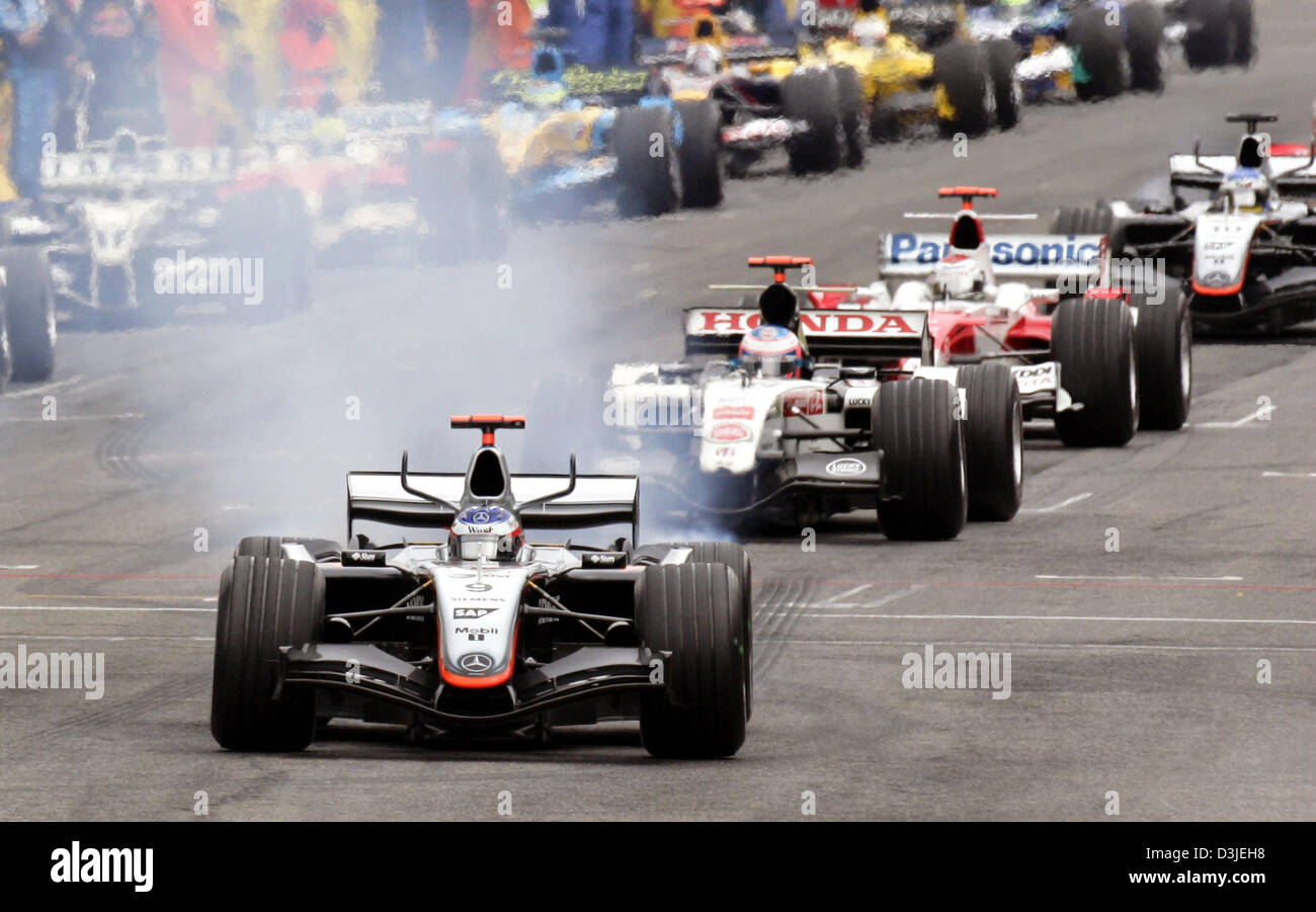 (Dpa) - La Fórmula Uno finlandés Kimi Raeikkoenen (delantero) de McLaren Mercedes comienza a salir humo de su coche de carreras en la pista de Fórmula Uno en el inicio del Gran Premio de San Marino en Imola, Italia, 24 de abril de 2005. Foto de stock