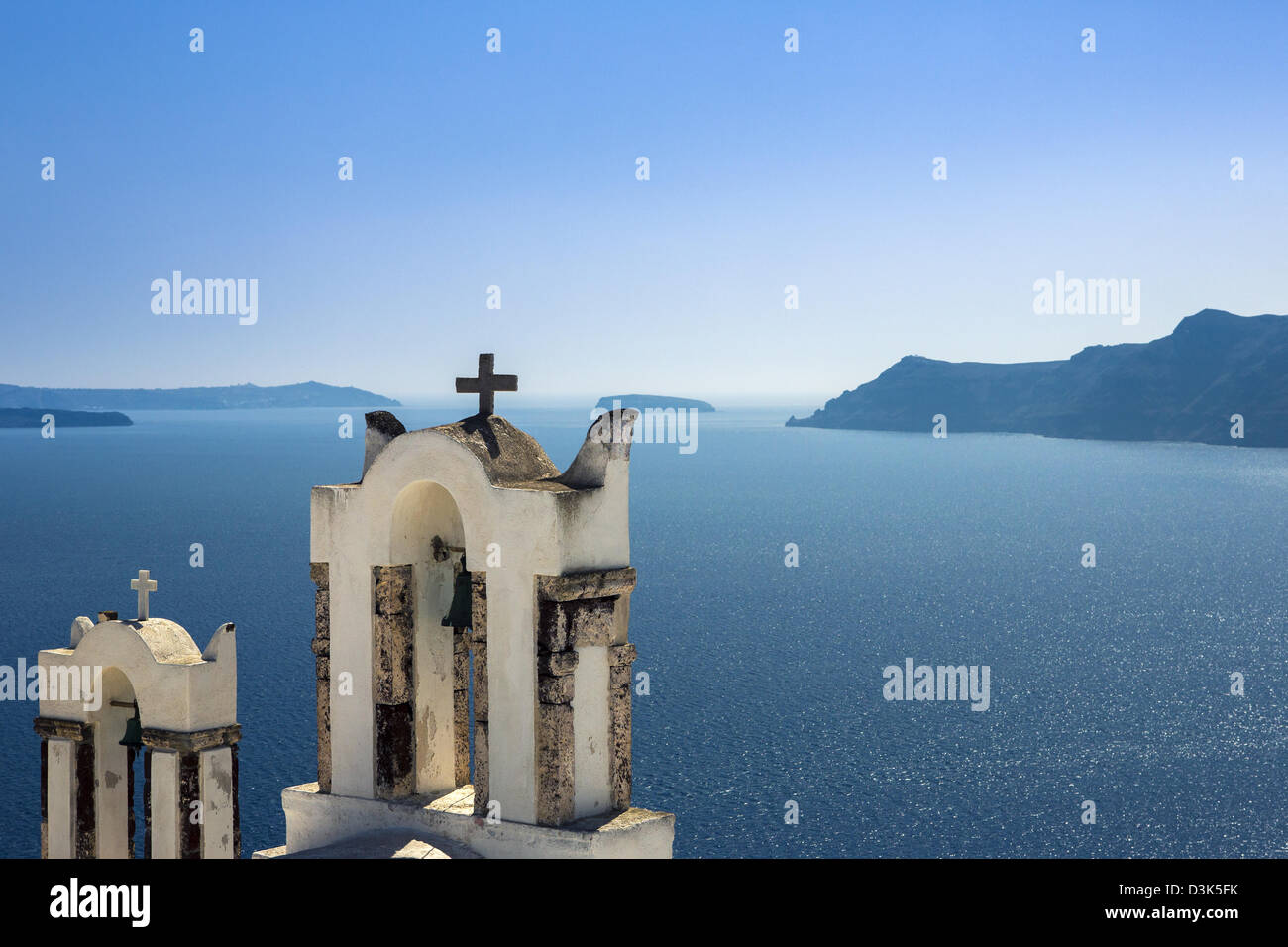 Dos campanarios de una iglesia mirando el caldra de Santorini. Foto de stock