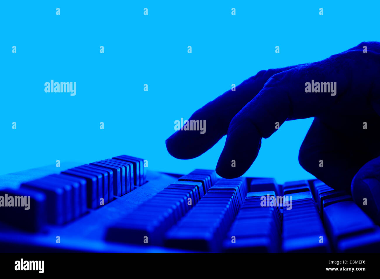 Acercamiento de los dedos sobre el teclado azul Foto de stock