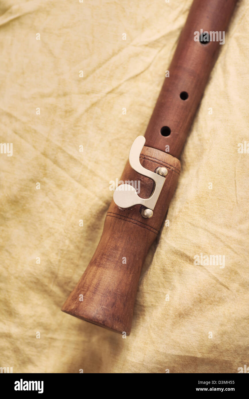 Detalle del instrumento musical, la flauta de madera tumbado sobre productos textiles Foto de stock
