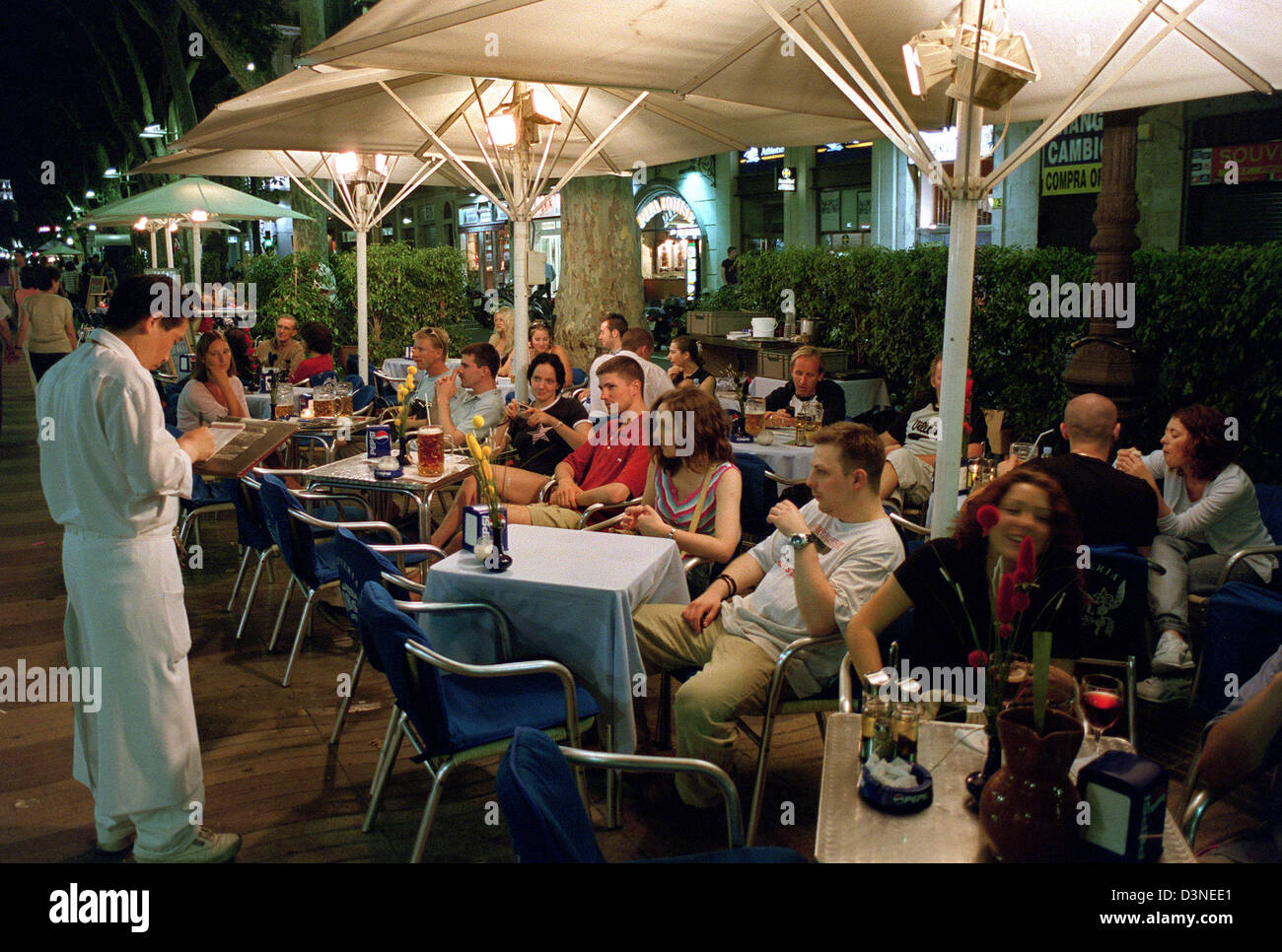 La imagen muestra la aglomeración de personas en uno de los numerosos cafés de la calle por la noche en las Ramblas de Barcelona, España, 10 de junio de 2002. Foto: Thorsten Lang Foto de stock