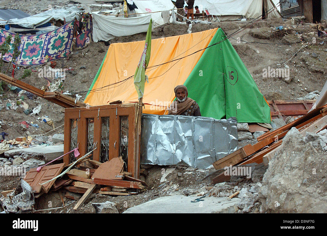 Un hombre se sienta en las ruinas de su casa para fortificar su mandato a través de su presencia, de Balakot, Pakistán, Martes 31 de enero de 2006. Aproximadamente 20.000 personas murieron en la ciudad de Balakot, una de las cuales el 95% fueron destruidos durante el terremoto del 08 de octubre de 2005. El terremoto de magnitud 7.6 azotó la región de Cachemira, en el noroeste de Pakistán y mató a 80.000 personas. Tres millones quedaron homeles Foto de stock