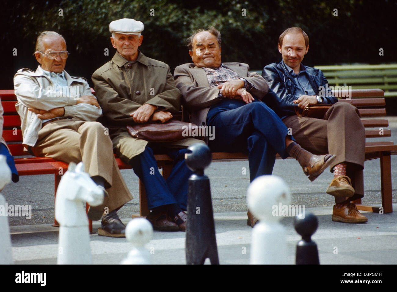 Berlín, RDA, hombres sentados en un banco del parque en el parque de Friedrichshain Foto de stock